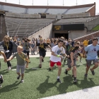 Kids exploring Kinnick football field at UISPEAKS camp kinnick tour 2022, photo by jtobin