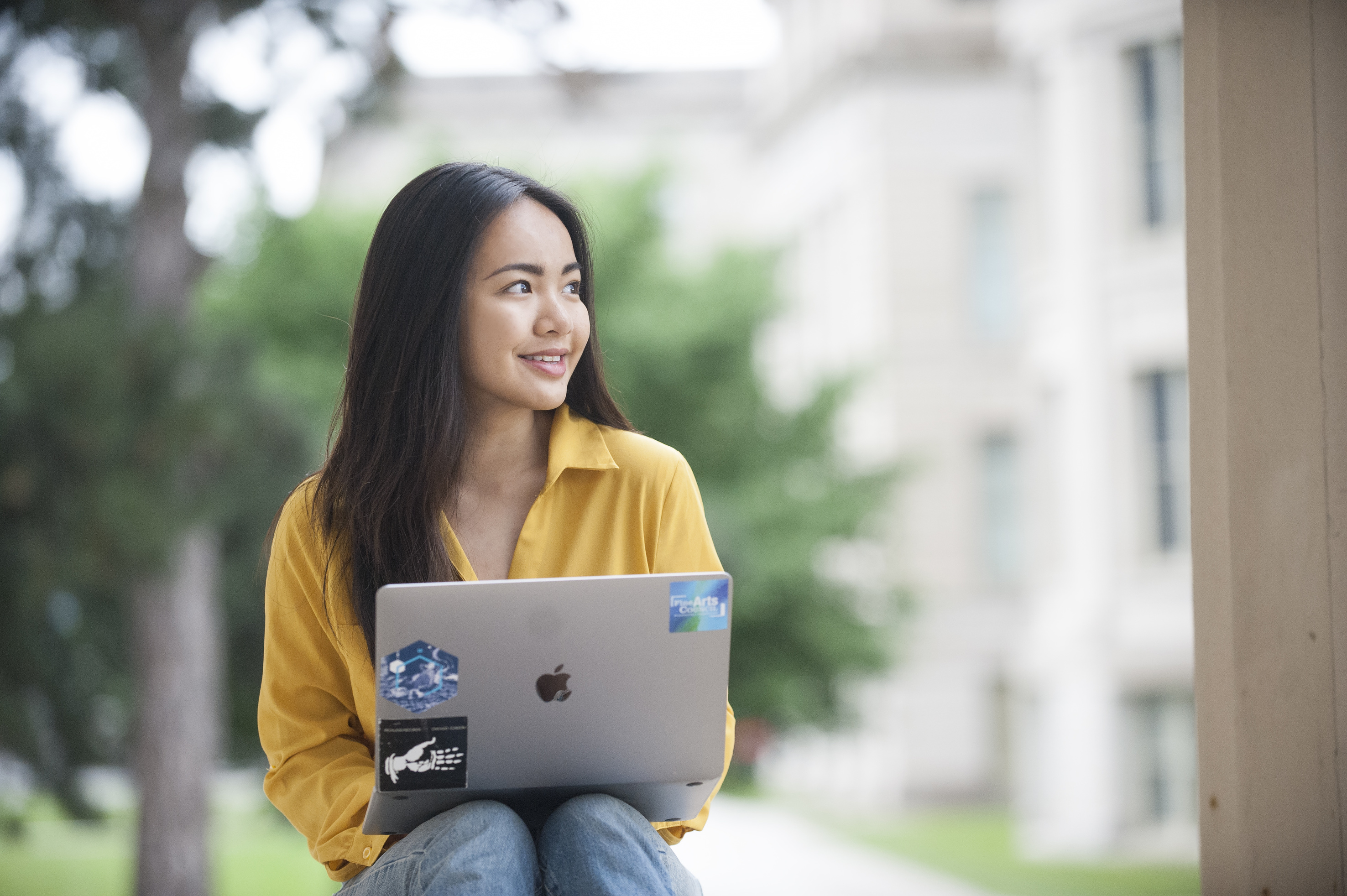 a student studying on her laptop outside on the Old Capitol steps