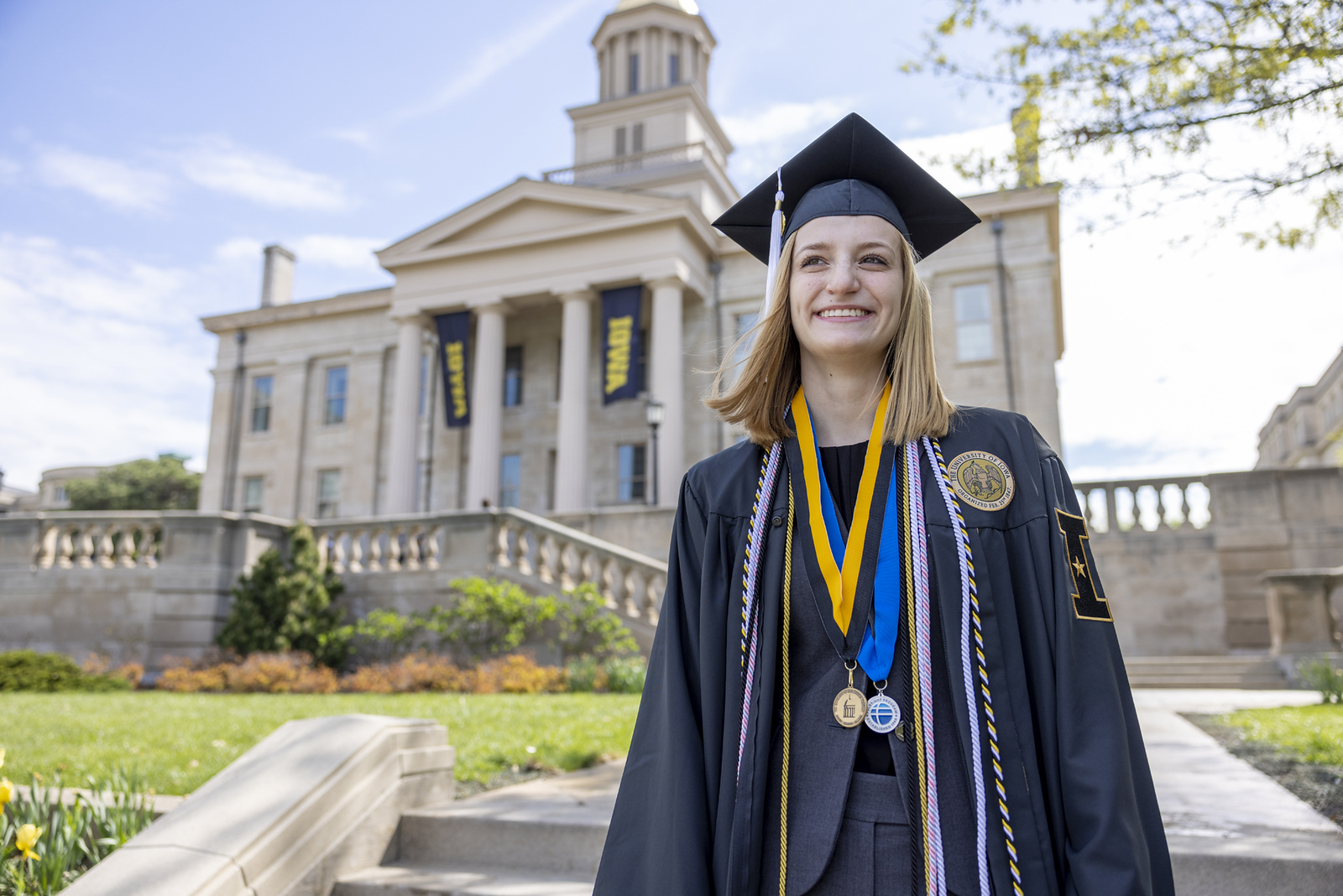 portrait of Eleanor Hildebrandt in cap and gown in front of Old Cap