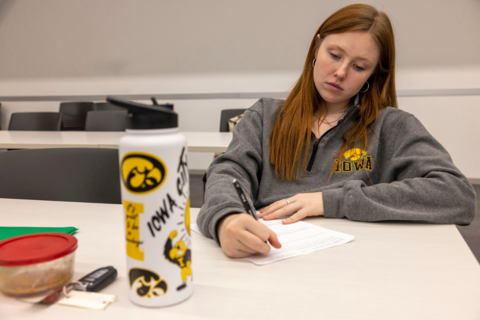 A student in hawkeye gear working hard at studying