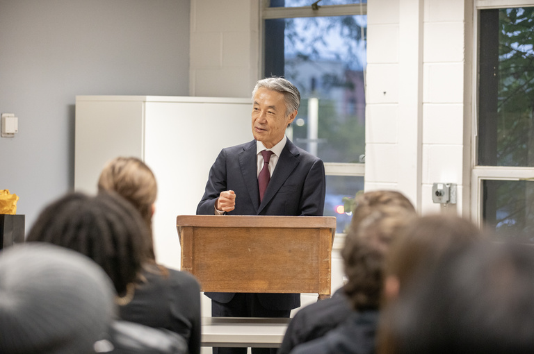 The Japanese Ambassador speaking at a podium in front of students